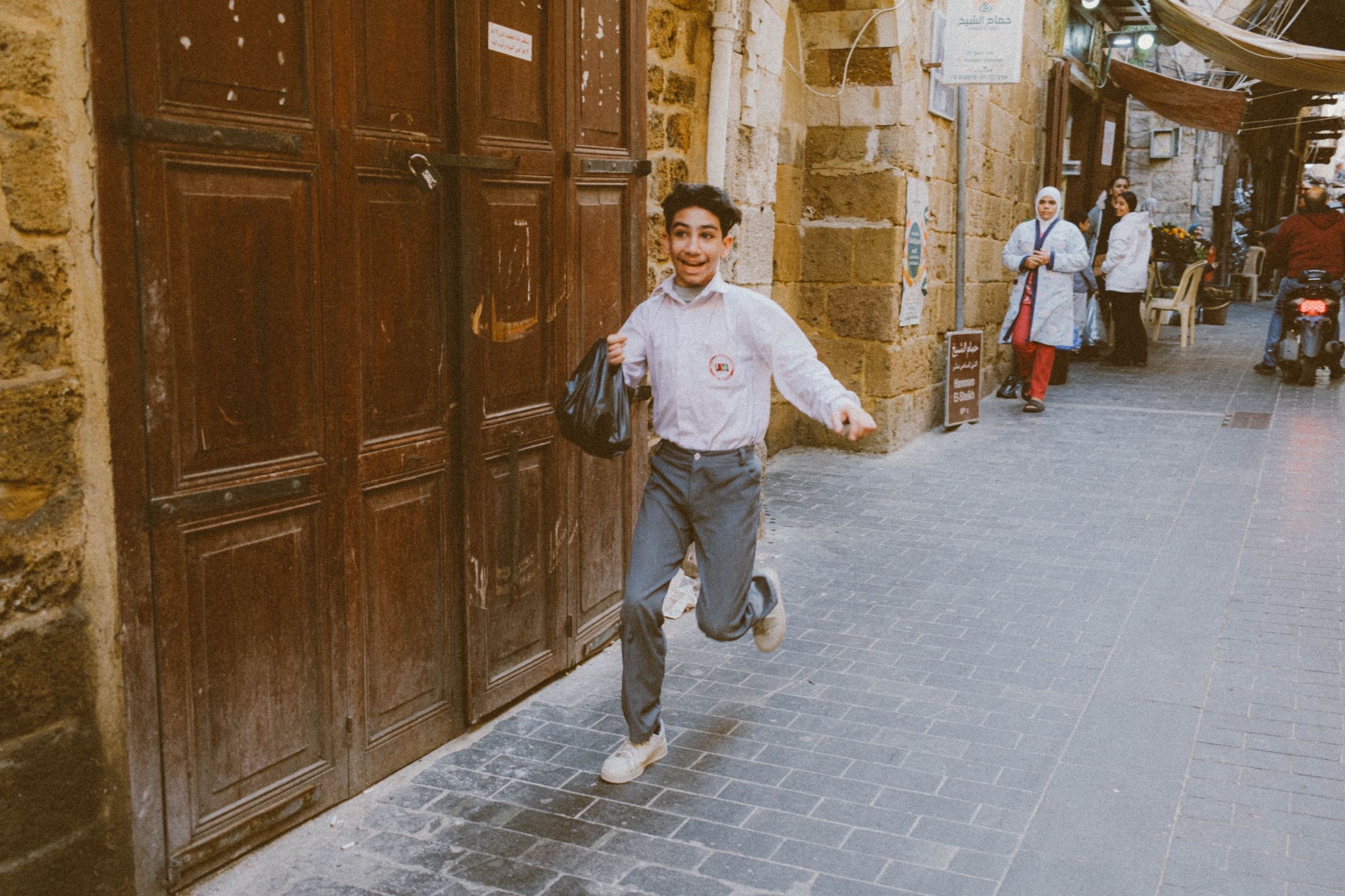 A candid photo of a young boy happily running in one of Sidon’s old streets.