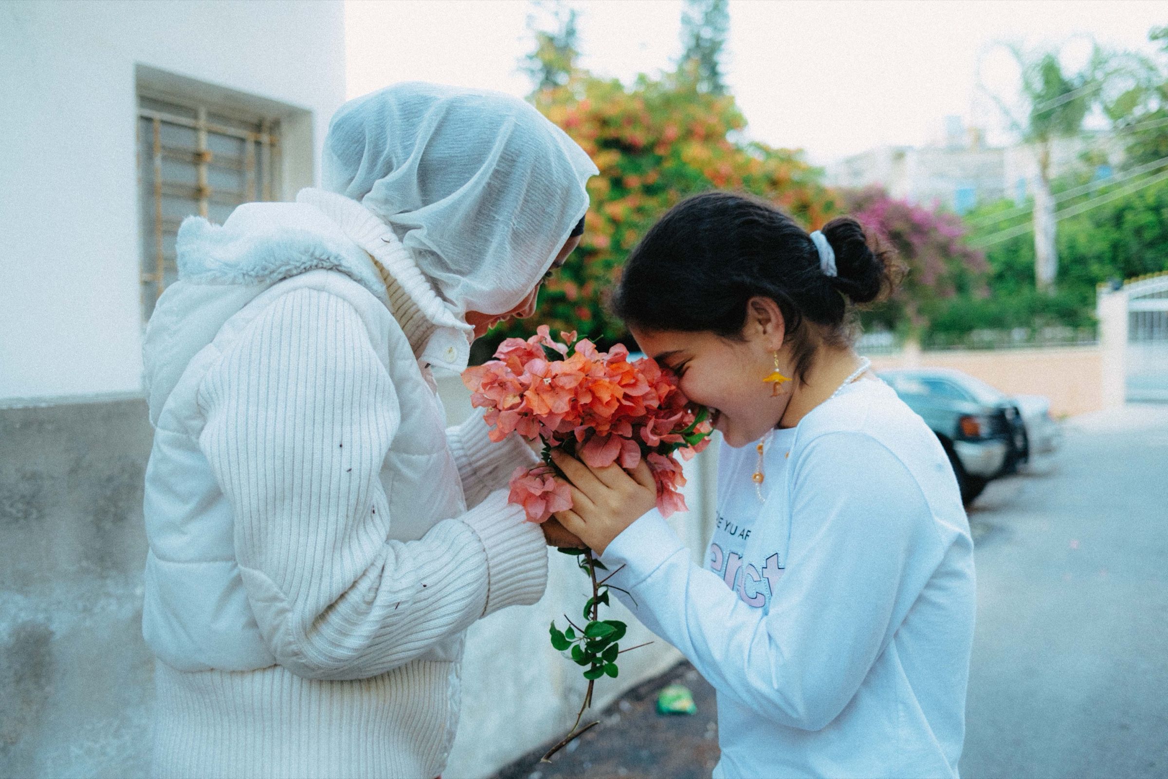 A candid photo of two friends holding a flower in the town of Joun, Lebanon.